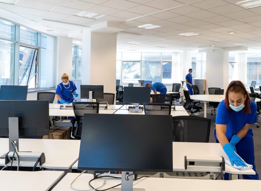 Professional cleaners with the masks on their faces clean and di Professional cleaners with the masks on their faces clean and di